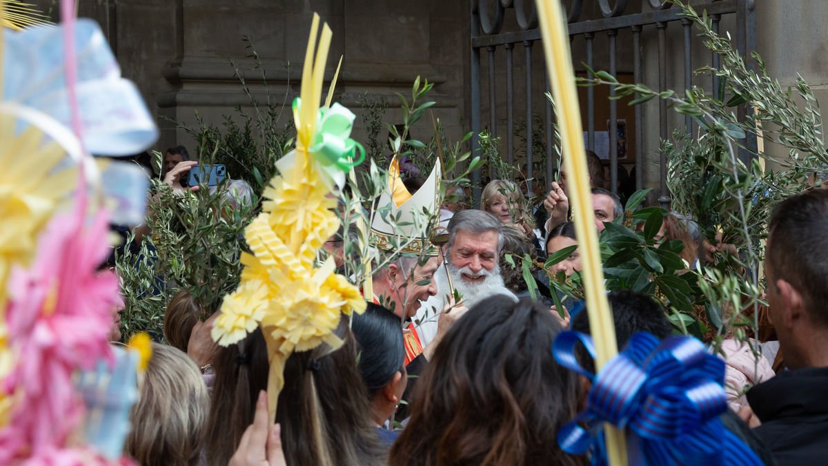 Lleida. El obispo de Lleida, Salvador Giménez, durante la bendición de las palmas, palmones y los ramos de olivo y de laurel en las puertas de la Catedral Nova. - BISBAT D’URGELL