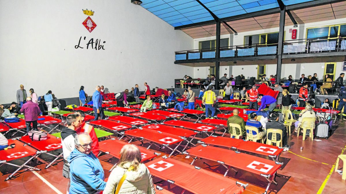 El pabellón de L’Albi, donde se habilitaron decenas de camas para pasar la noche. Abajo a la derecha, los Bomberos de Huesca evacuando el tren de alta velocidad en Saidí. - JOAN GÓMEZ