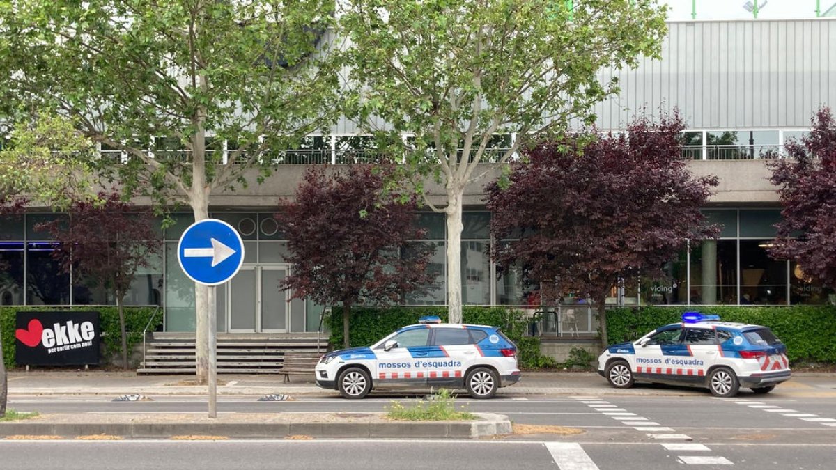 Dos coches de los Mossos d’Esquadra en el exterior del gimnasio.