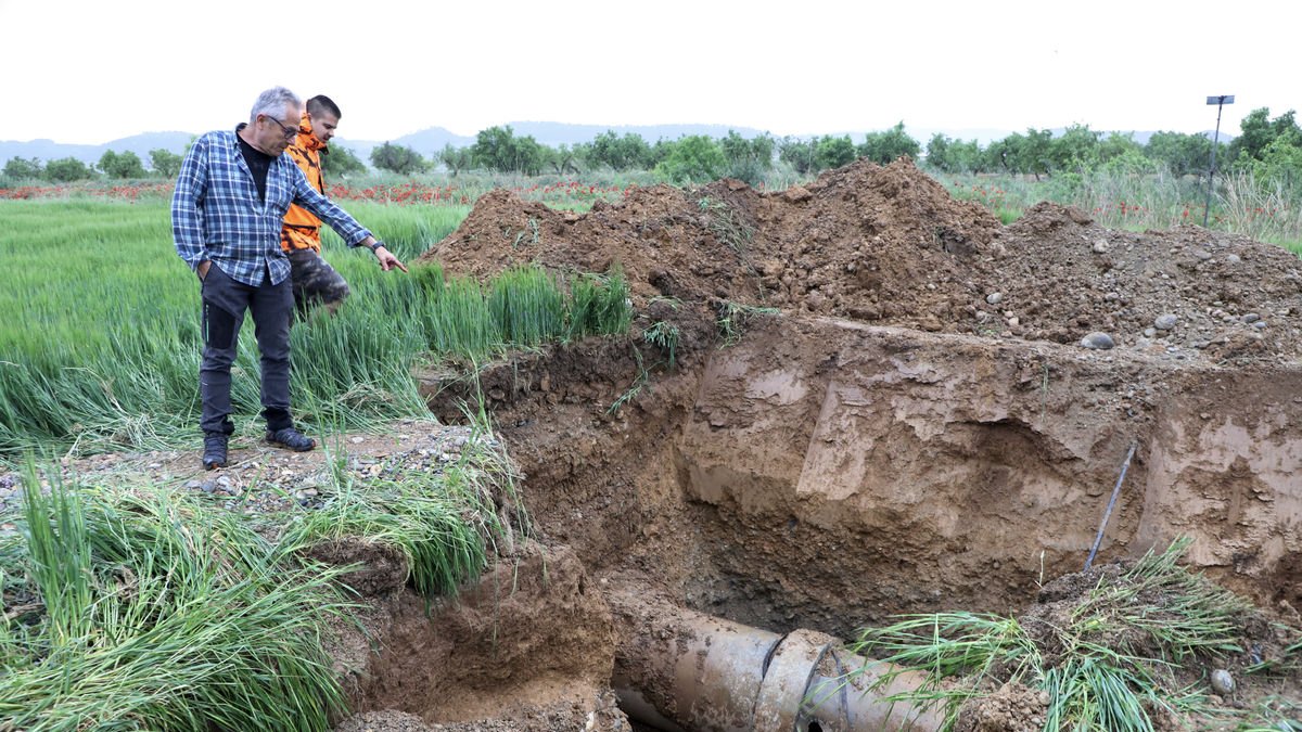 Técnicos de la comunidad de regantes señalan el agujero en la tubería de agua, de unos 20 centímetros. - CHE
