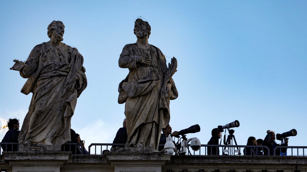 Los periodistas esperan en la Plaza de San Pedro mientras comienza el cónclave para elegir un nuevo papa, en el Vaticano.