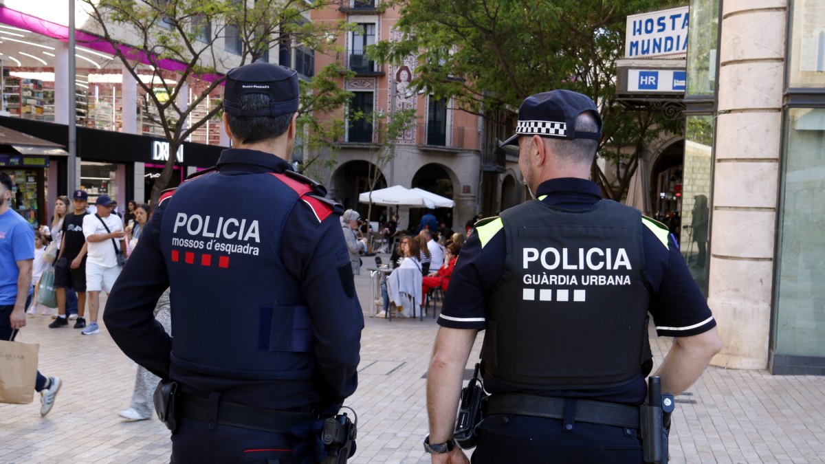 Un agent dels Mossos d'Esquadra i un de la Guàrdia Urbana de Lleida a l'Eix Comercial de Lleida.