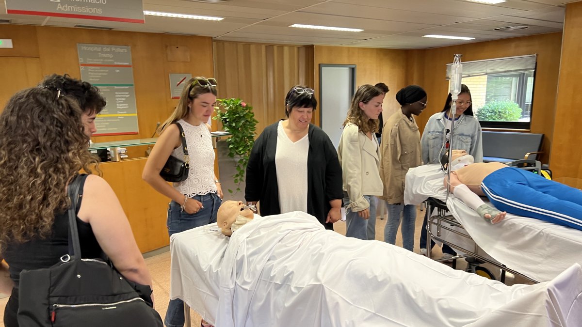Un grupo de personas interesadas en estudiar enfermería en el Pirineo, observando materiales didácticos en las instalaciones del Hospital Comarcal del Pallars.