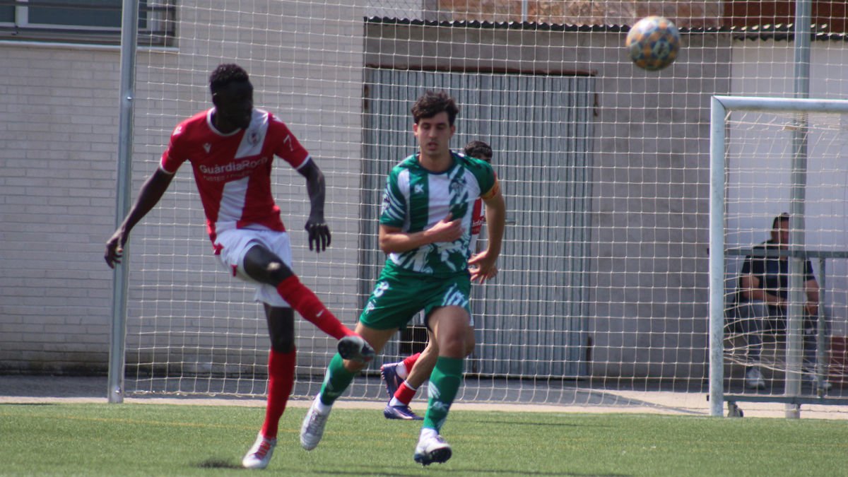 Un jugador de l’Artesa de Segre rebutja la pilota davant de la presència d’un jugador rival. - JOAN BOVÉ
