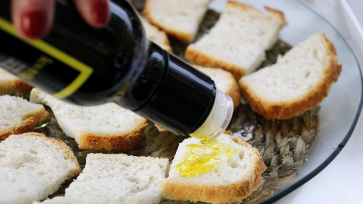 Raig d'oli d'oliva verge extra damunt d'una llesca de pa.