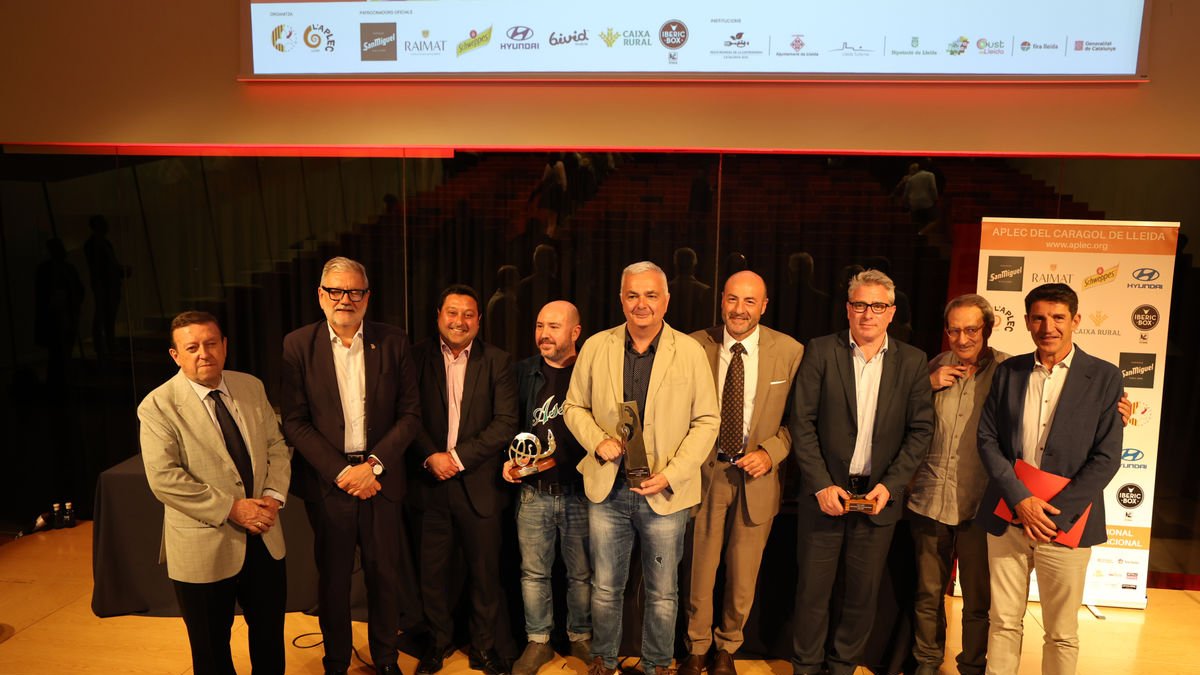 El periodista Artur Peguera, a la derecha, con los premiados, el alcalde de Lleida y miembros de la Fecoll ayer tarde en la Llotja. - AMADO FORROLLA