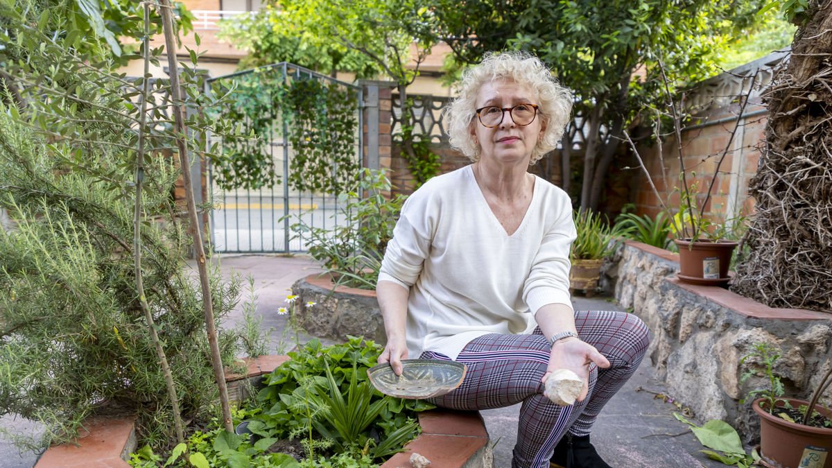La veïna mostra un objecte decoratiu del seu jardí trencat per una pedrada, amb altres pedres al costat. - JORDI ECHEVARRIA
