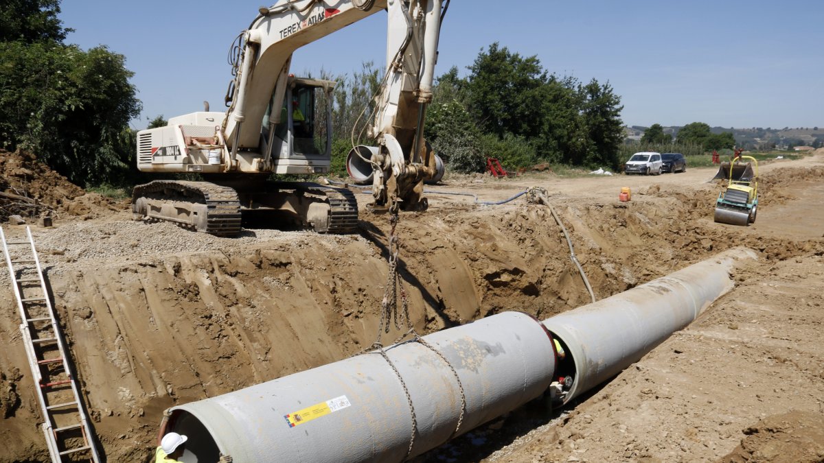 Operaris instal·lant un tub de reg en el marc dels treballs de modernització del canal de Pinyana, a Alguaire.