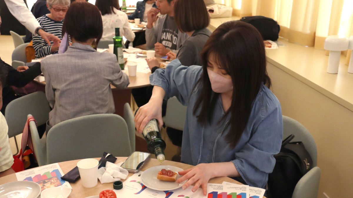 Una visitant a l'Expo d'Osaka fent el taller de pa amb tomàquet