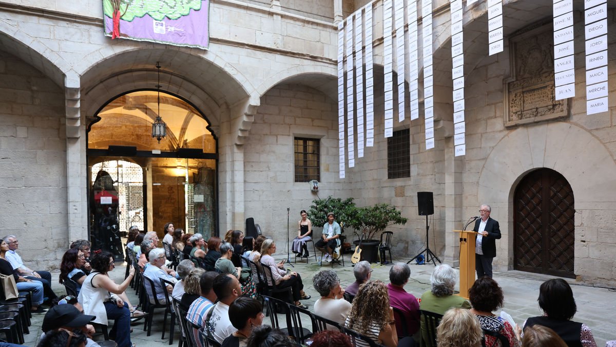 L’acte de commemoració de les víctimes, amb la llista de noms penjada, ahir al pati de l’IEI. - AMADO FORROLLA