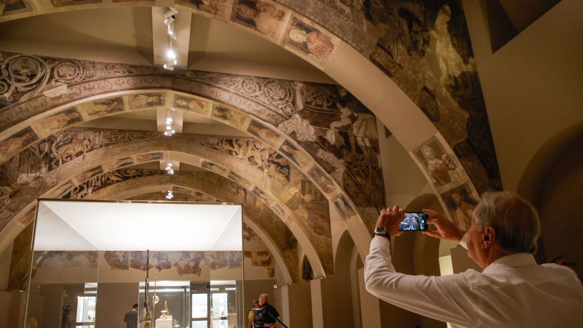 Un visitant, fent fotos dels murals de Sixena al MNAC. - KIKE RINCÓN / EUROPA PRESS