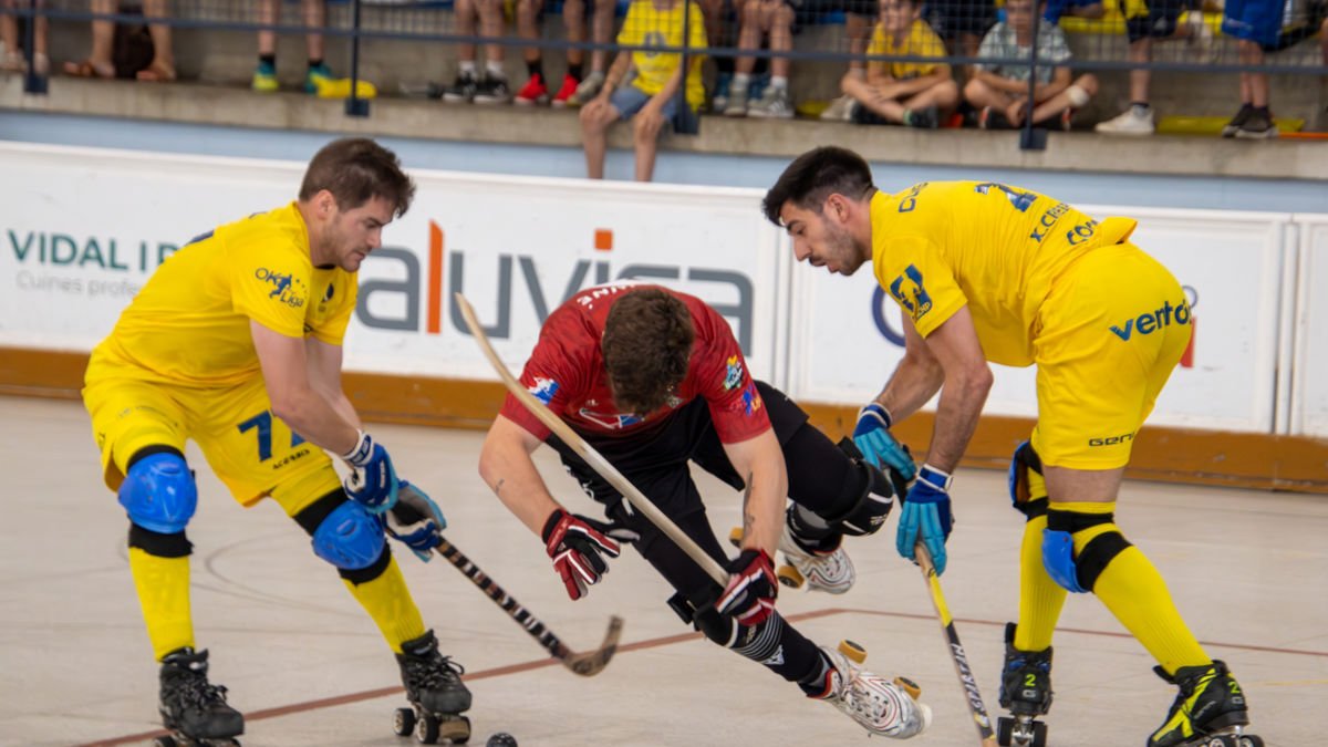 Un jugador de l’Alpicat cau entre dos jugadors del Sant Just, en una acció del partit d’ahir. - ANIOL MORAL