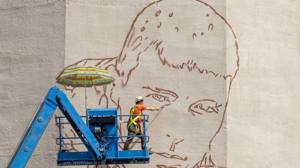 L’artista Oriol Arumí, ahir al mural que està pintant amb la imatge de Jorge Delgado a Balàfia
