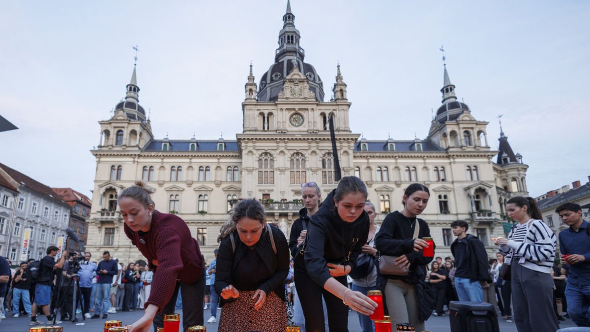 Un grupo de jóvenes encienden velas en memoria de las víctimas del tiroteo masivo Graz. - ERWIN SCHERIAU / APA / DPA