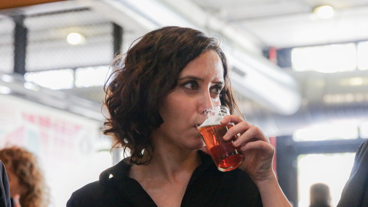 La presidenta de la Comunidad de Madrid, Isabel Díaz Ayuso, se bebe una caña de cerveza durante una visita a una fábrica de cerveza artesanal en una imagen de archivo.