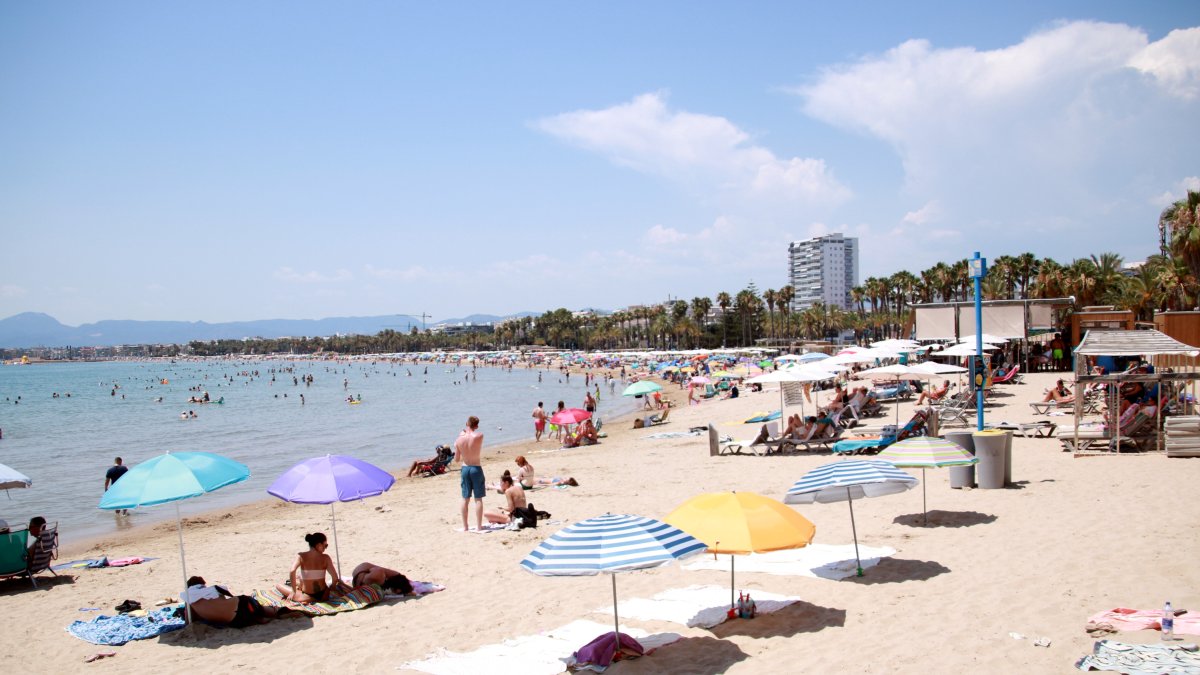 Turistes i banyistes prenent el sol i banyant-se a la platja de Salou