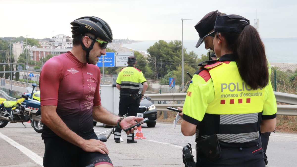 Un ciclista muestra su documentación a los Mossos d'Esquadra en un control de tráfico.