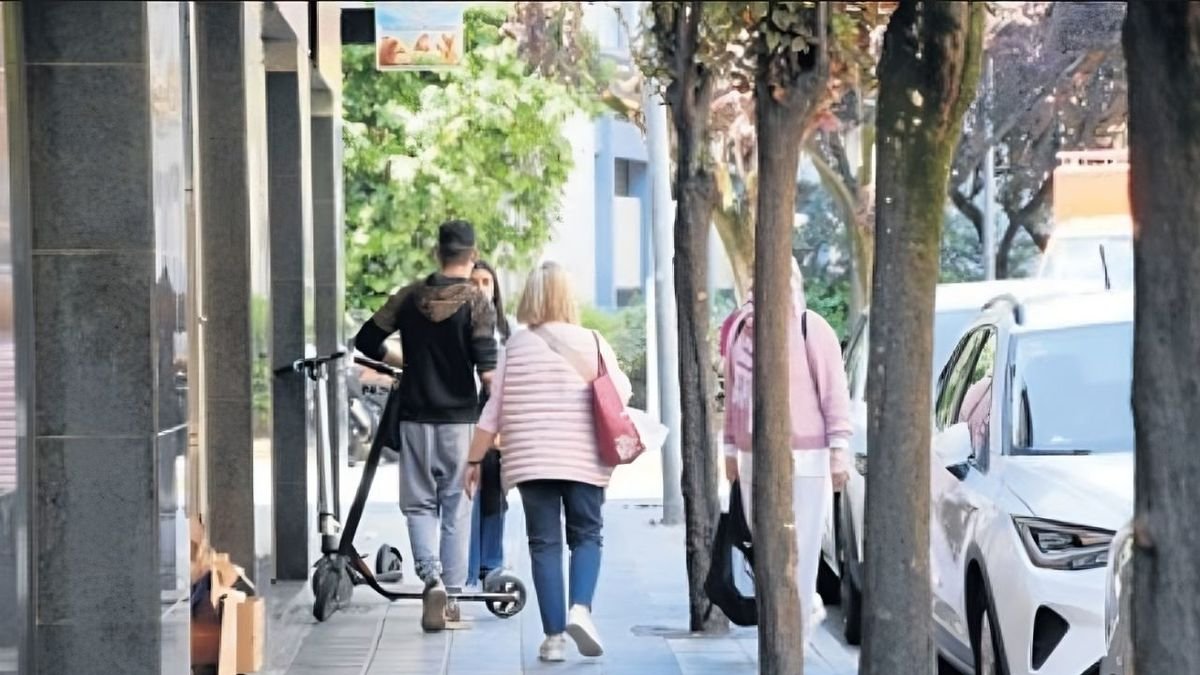 Un usuario con patinete circulando por una acera de La Seu. - C.SANS