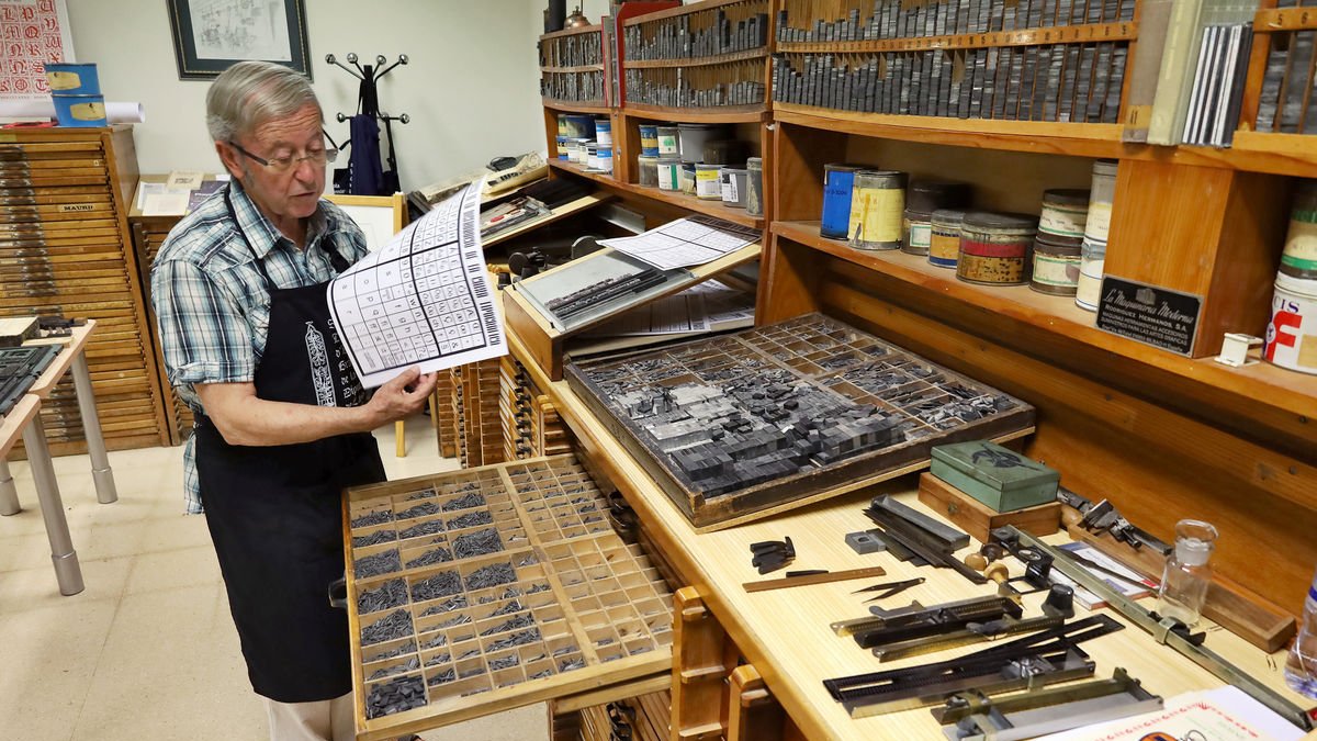 Dionís Gutiérrez. El tipògraf ens guia per les instal·lacions i ens mostra antigues  peces metàl·liques de la impremta.