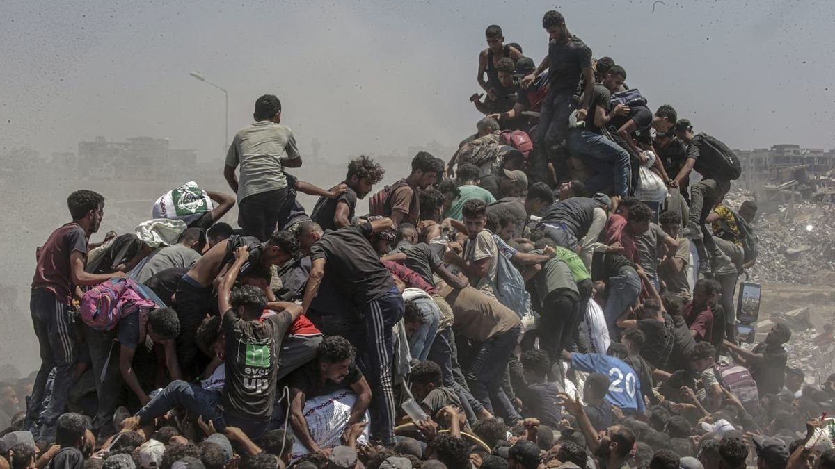 Palestinos intentan conseguir sacos de harina de un camión. - EFE/MOHAMMED SABER