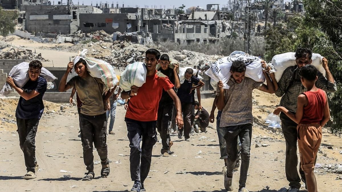 Joves carreguen sacs d’ajuda alimentària a Rafah. - ABED RAHIM KHATIB / DPA