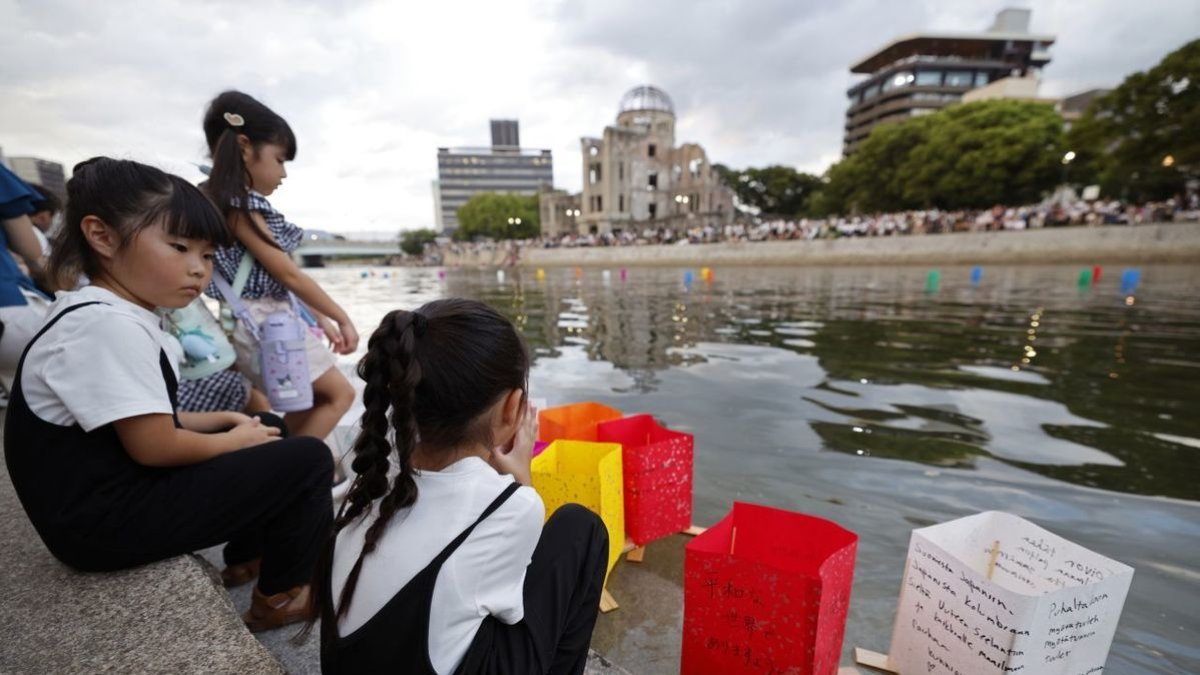 Unes nenes observen al riu Motoyasu els fanalets de paper en memòria de les víctimes de l’atac nuclear. - EUROPA PRESS