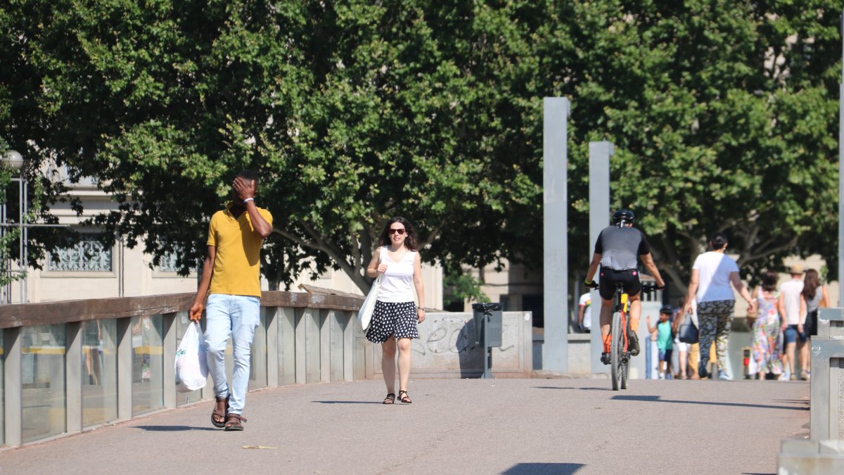 Vianants caminant per Lleida durant el primer dia d'onada de calor