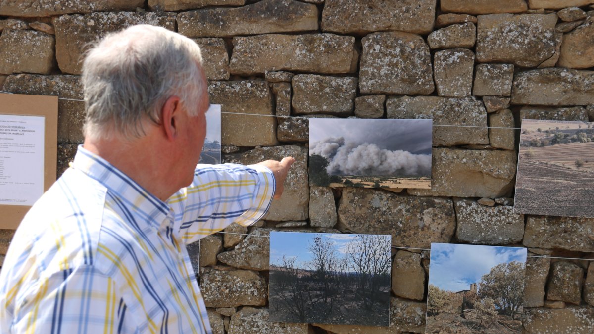 Joan Graells, veí de Granollers de Segarra, assenyala una fotografia de l'exposició de l'Incendi de Torrefeta i Florejacs.