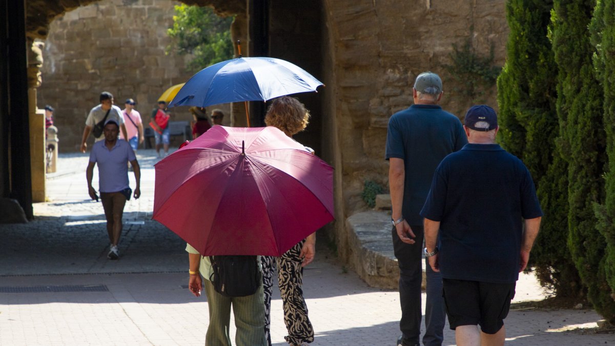 Persones amb parasol pel Turó de la Seu Vella de Lleida.
