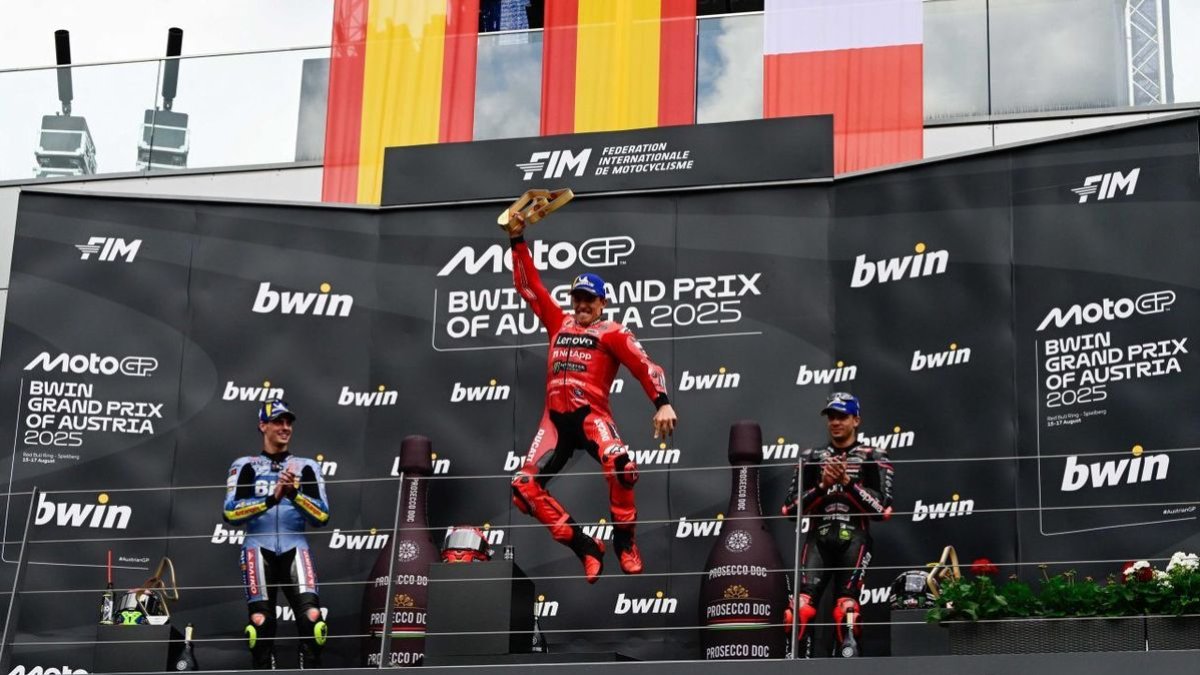 Marc Márquez salta en el podio con el trofeo de campeón en la mano, el noveno que logra en la carrera del domingo esta temporada. - MOTOGP