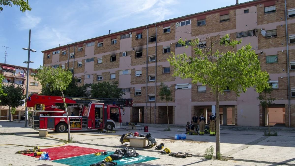 Bombers davant el bloc afectat per l’incendi, el 22 de juliol.