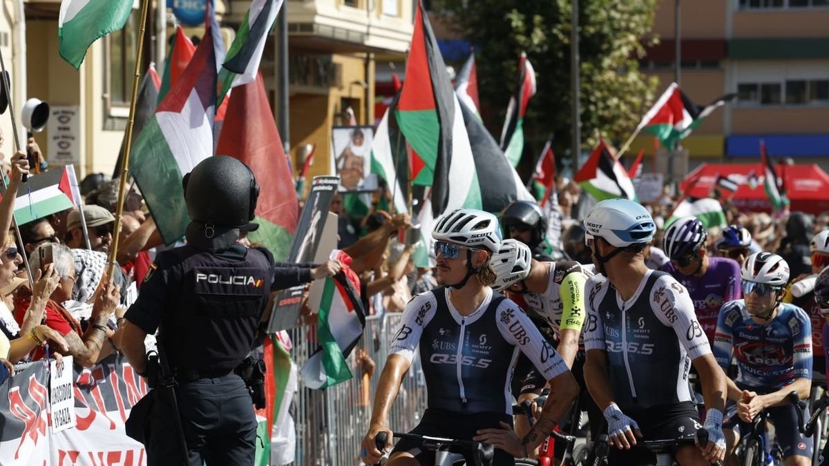 Ciclistas observan las protestas, ayer en la salida de la etapa. - EFE