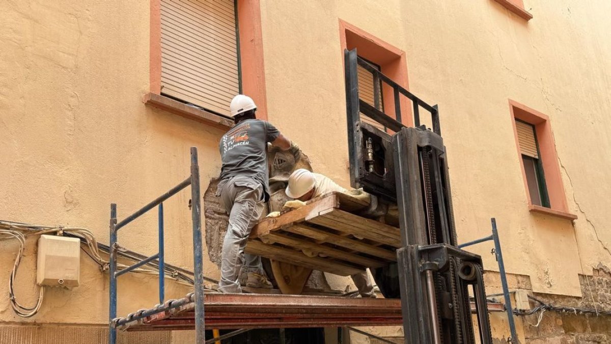 Momento de la colocación del escudo nobiliario en la fachada de donde fue extraído. - AYUNTAMIENTO DE FRAGA