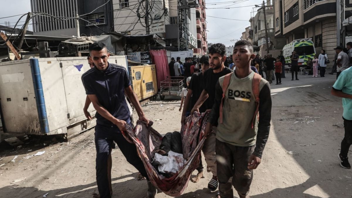 Gazatíes llevando a un muerto en el campo de Nuseirat. - EUROPA PRESS