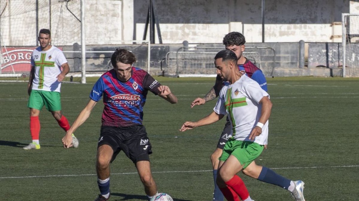 Un jugador del Puigreig intenta avançar metres davant de l’oposició d’un defensa del Tàrrega. - LAIA PEDRÓS