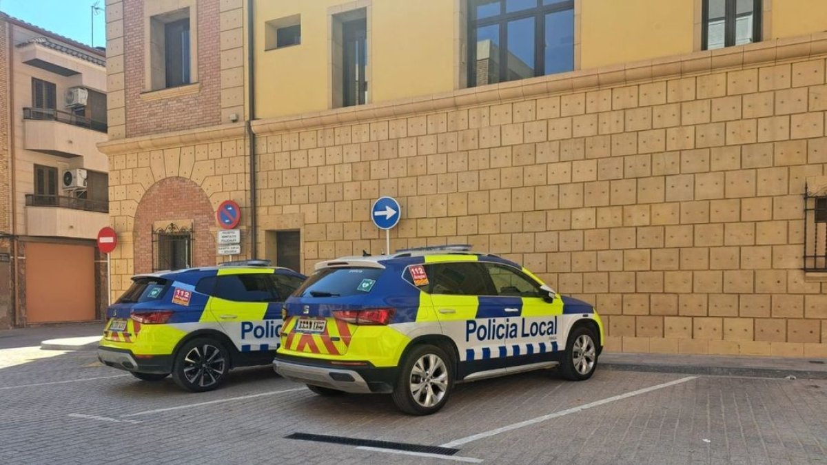 Dos vehículos de la Policía Local de Fraga aparcados en las plazas reservadas por el ayuntamiento.