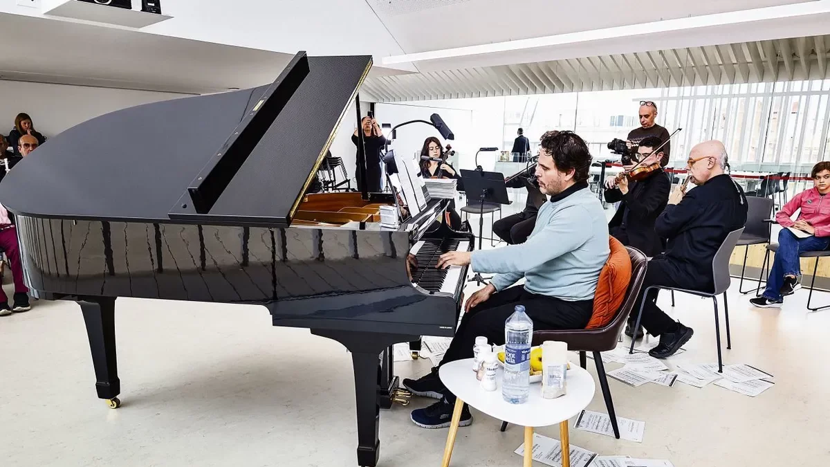 El pianista Joan Bagés, con comida y bebida a su alcance, y partituras en el suelo de fragmentos ya tocados. - INGRID SEGURA