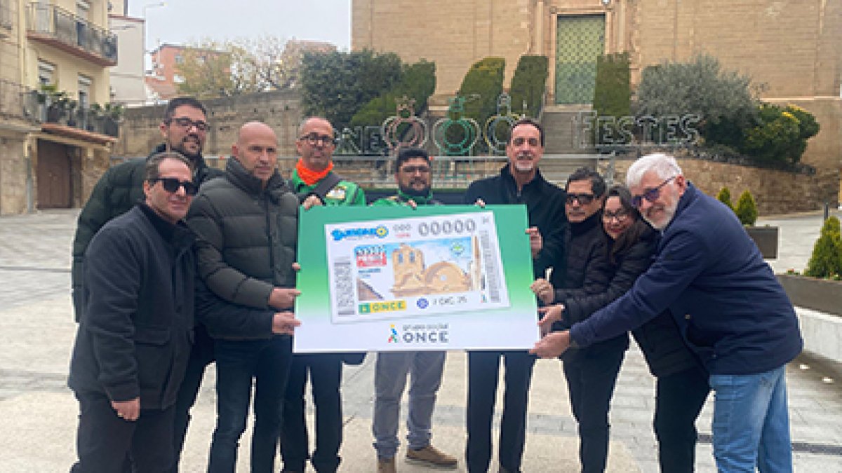 Jordi Castany, alcalde de Alcarràs, i la resta d'impulsors del cupó, posen amb la il·lustració.