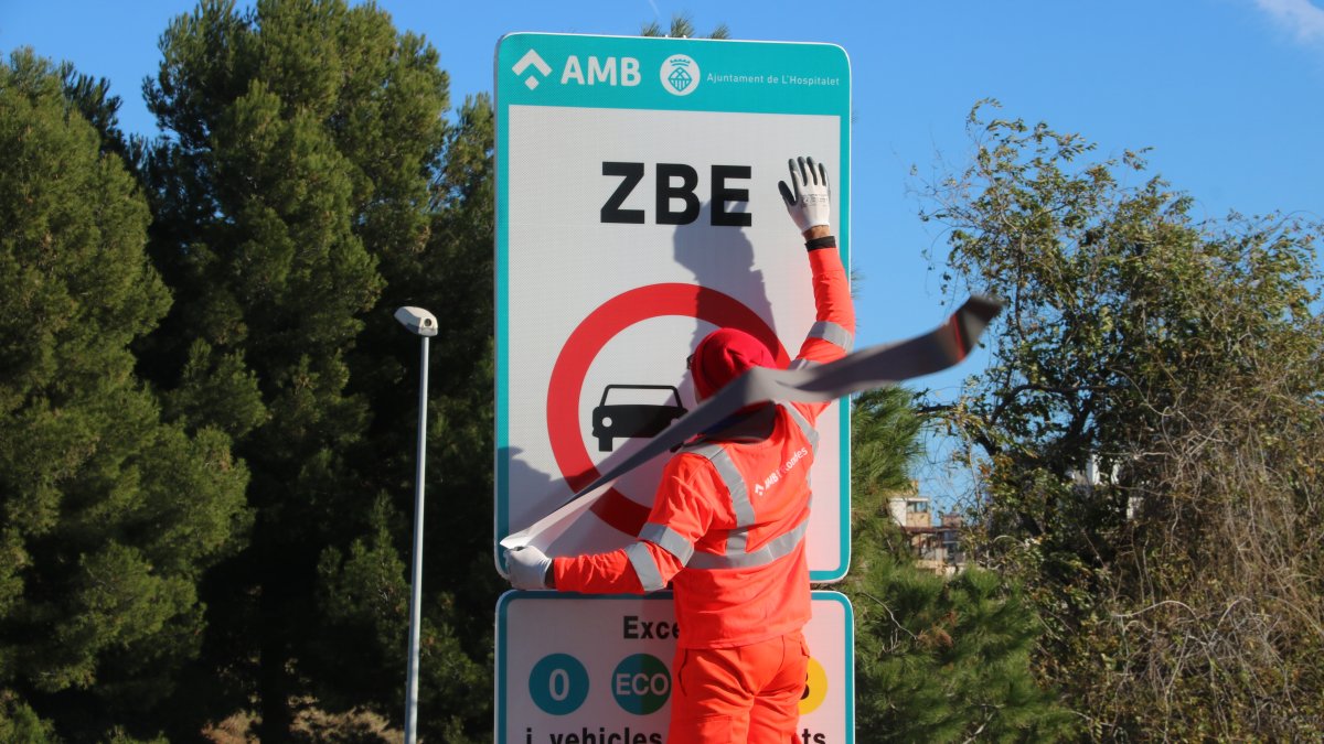 operaris instal·lant un senyal de la ZBE a l'Hospitalet en una imatge d'arxiu.
