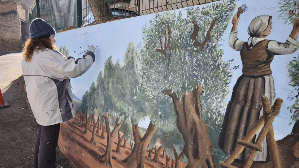 Ingrid Tost pintando el mural que ocupa 34 metros de pared en el centro de El Cogul. - A.E.C.