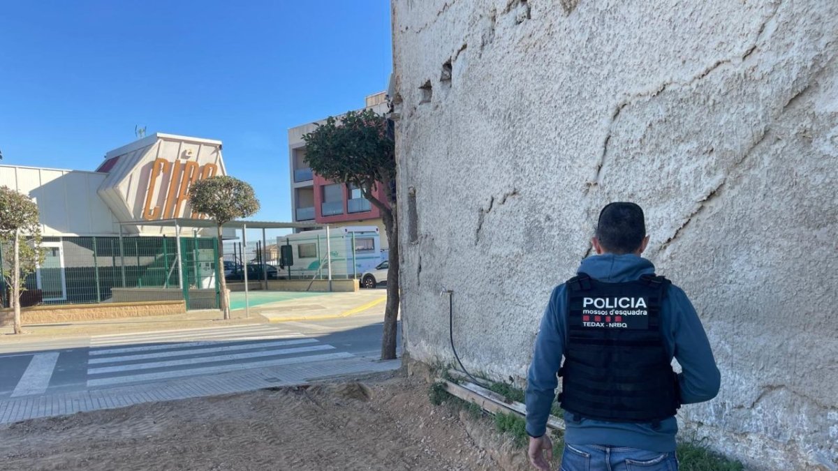 Un agente de los Mossos, en el solar donde se encontró la bomba.