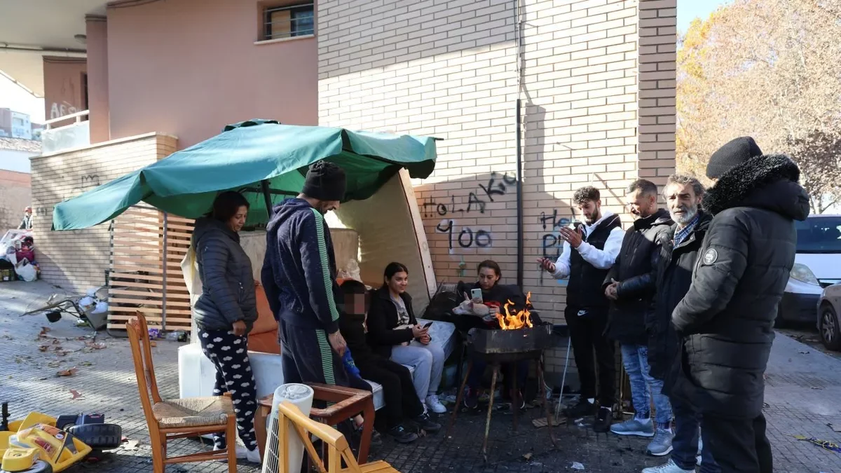 David Escudero, la seua dona, Rosario Jiménez, el seu fill i altres desallotjats, vora el bloc de pisos. - AMADO FORROLLA