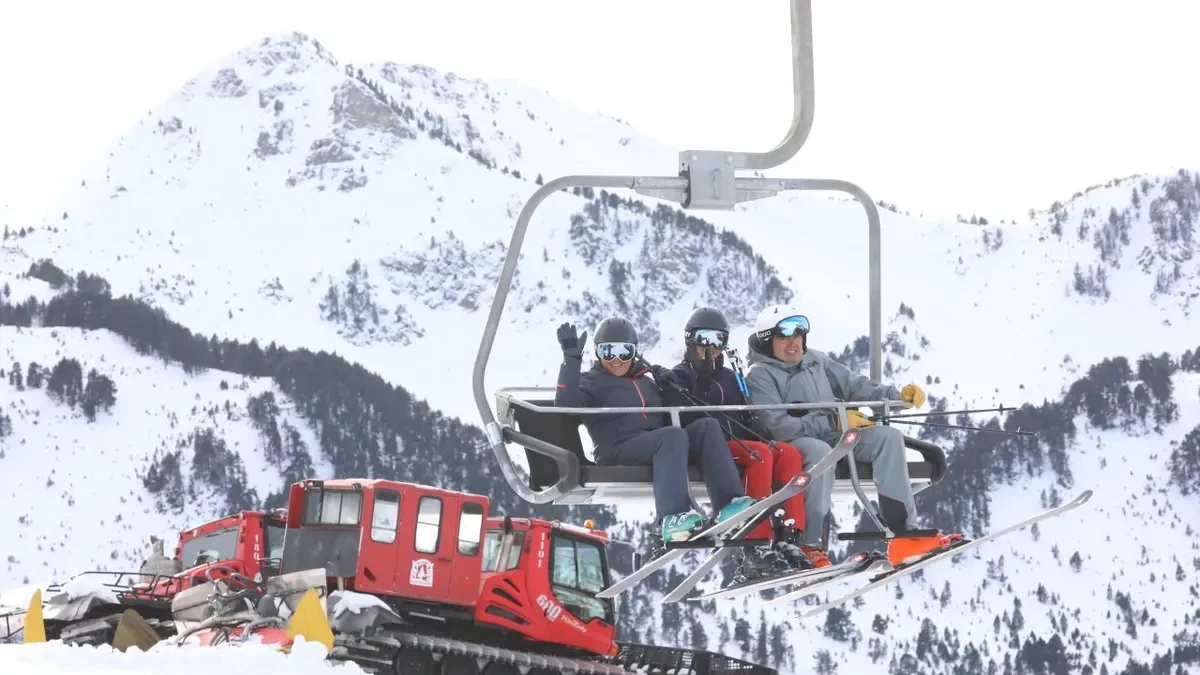 Un grup d’esquiadors en un remuntador de Baqueira-Beret amb màquines trepitjaneu al fons. - EDGAR ALDANA