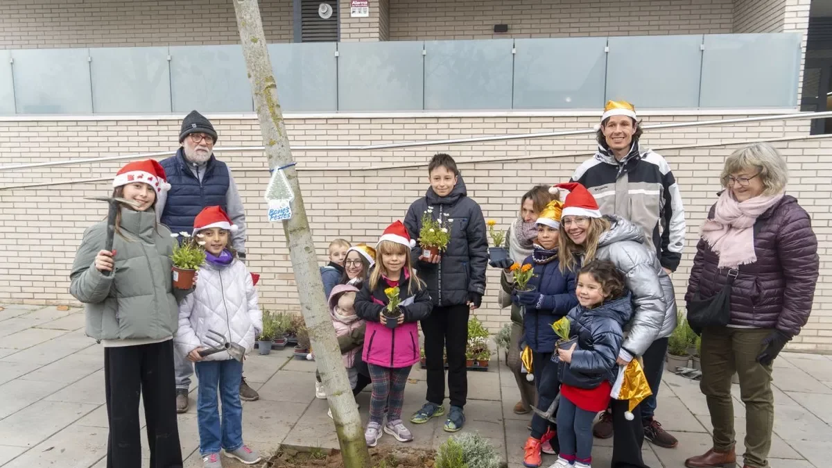 Les famílies que van enjardinar ahir escocells al carrer Camí de Picos. - PAU PASCUAL PRAT