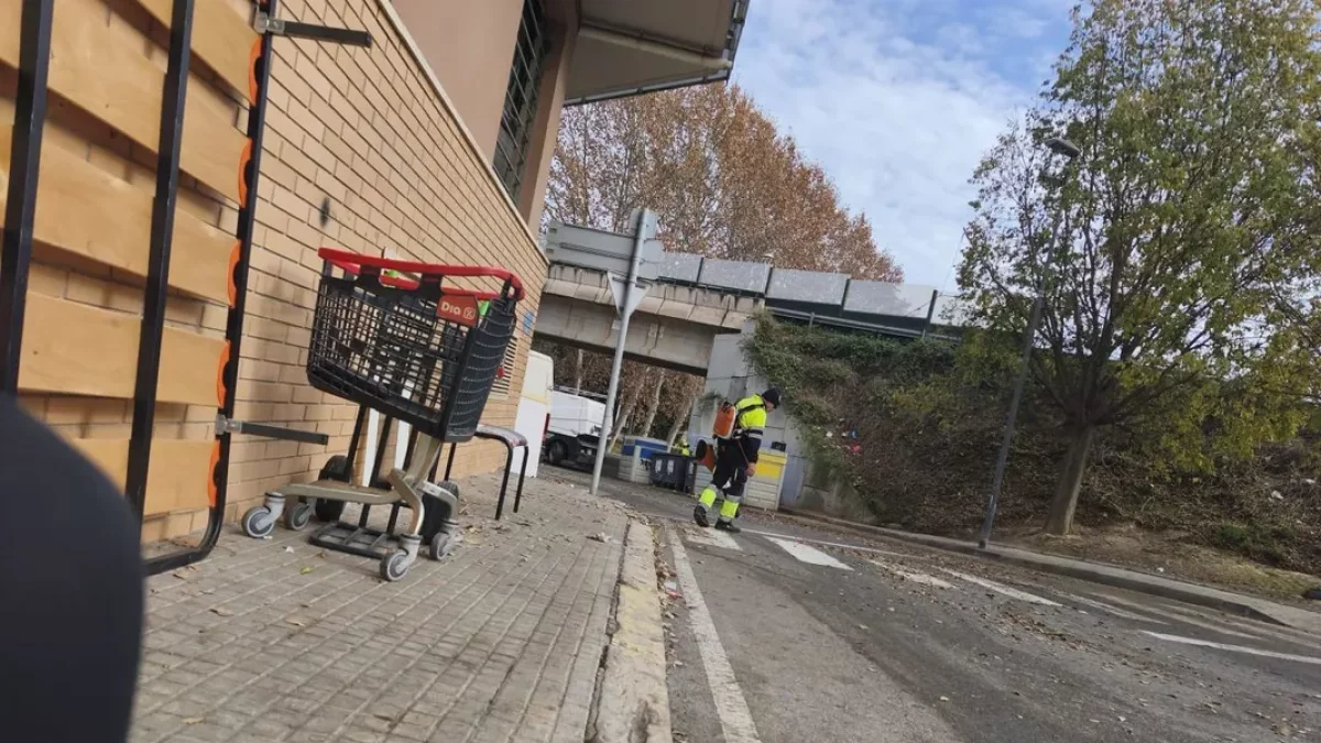 Un operari neteja la zona on dies abans acampava una família en un refugi fet amb mobles.