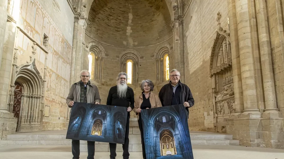 Miembros de Amics de la Seu Vella, ayer ante el ábside, sujetando una foto que reproduce el fenómeno. - JORDI ECHEVARRIA