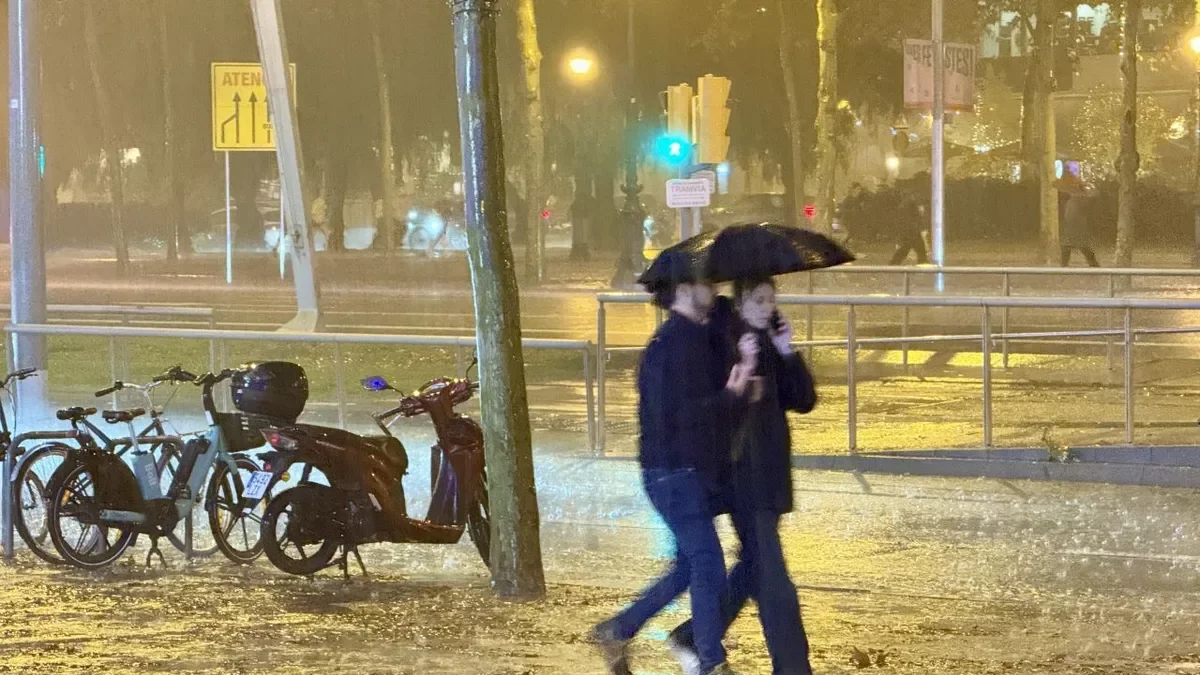 Una parella camina sota la pluja a l’altura d’Illa Diagonal, a Barcelona. - GERARD ESCAICH/ACN