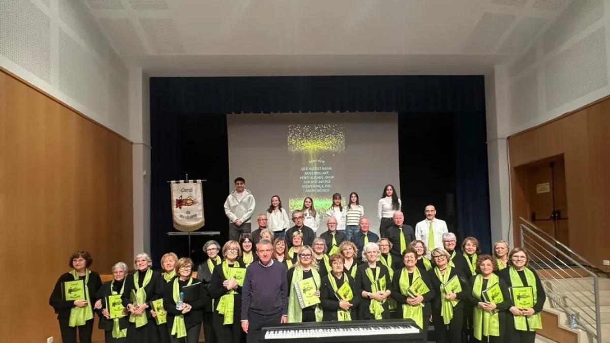 La coral, acompañada por el alcalde, Melcior Claramunt, y estudiantes que participaron en el concierto. - A.MIRALCAMP