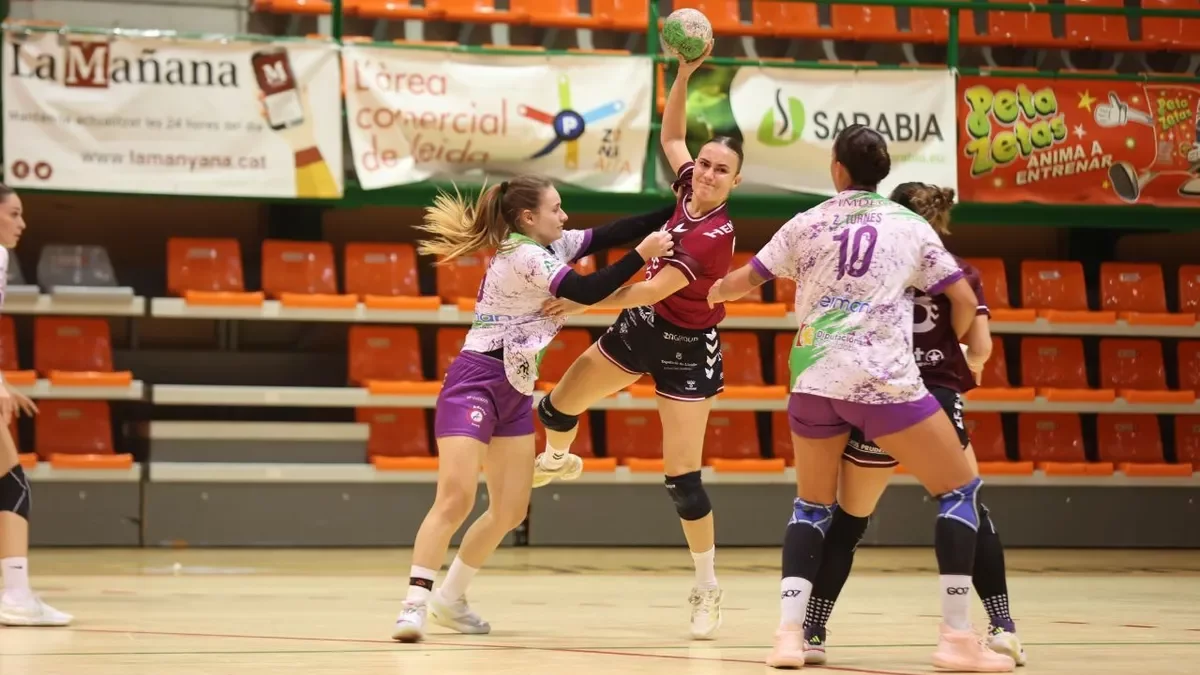 Una jugadora del Lleida Handbol pressionada per una rival del Còrdova. - AMADO FORROLLA