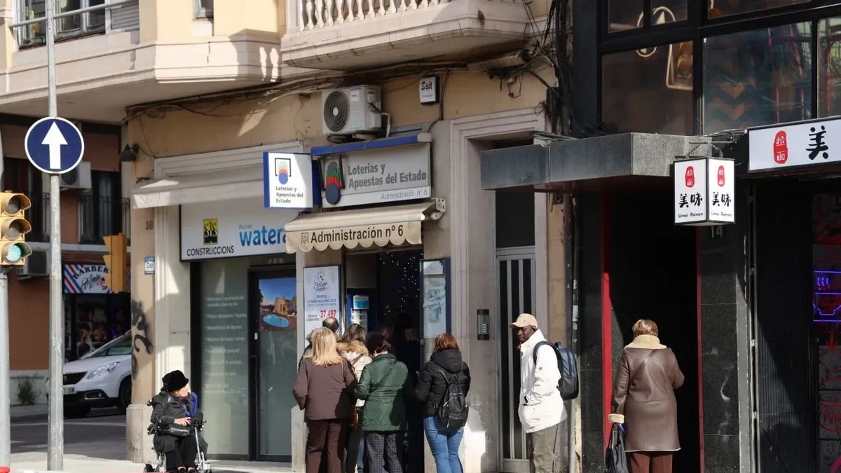 Gente haciendo cola ayer en una administración de loterías leridana para cobrar sus décimos. - AMADO FORROLLA